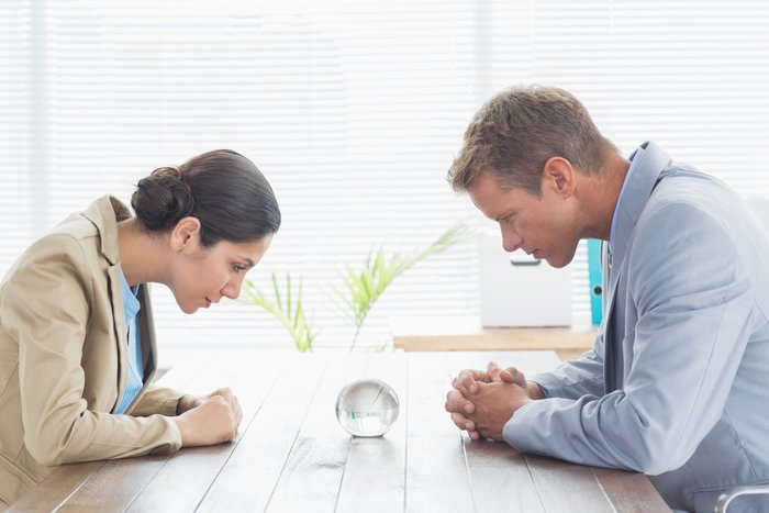 Семейная пара смотрит в стеклянный шар в надежде разглядеть будущеее